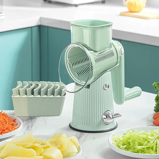 Green Rotary Cheese Grater and Shredder on white table with vegetables around.