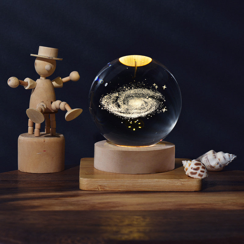 Wooden figure and galaxy-themed crystal ball on a wooden stand with a dark background