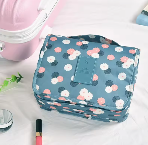 Floral patterned toiletry bag on a white surface with makeup items.